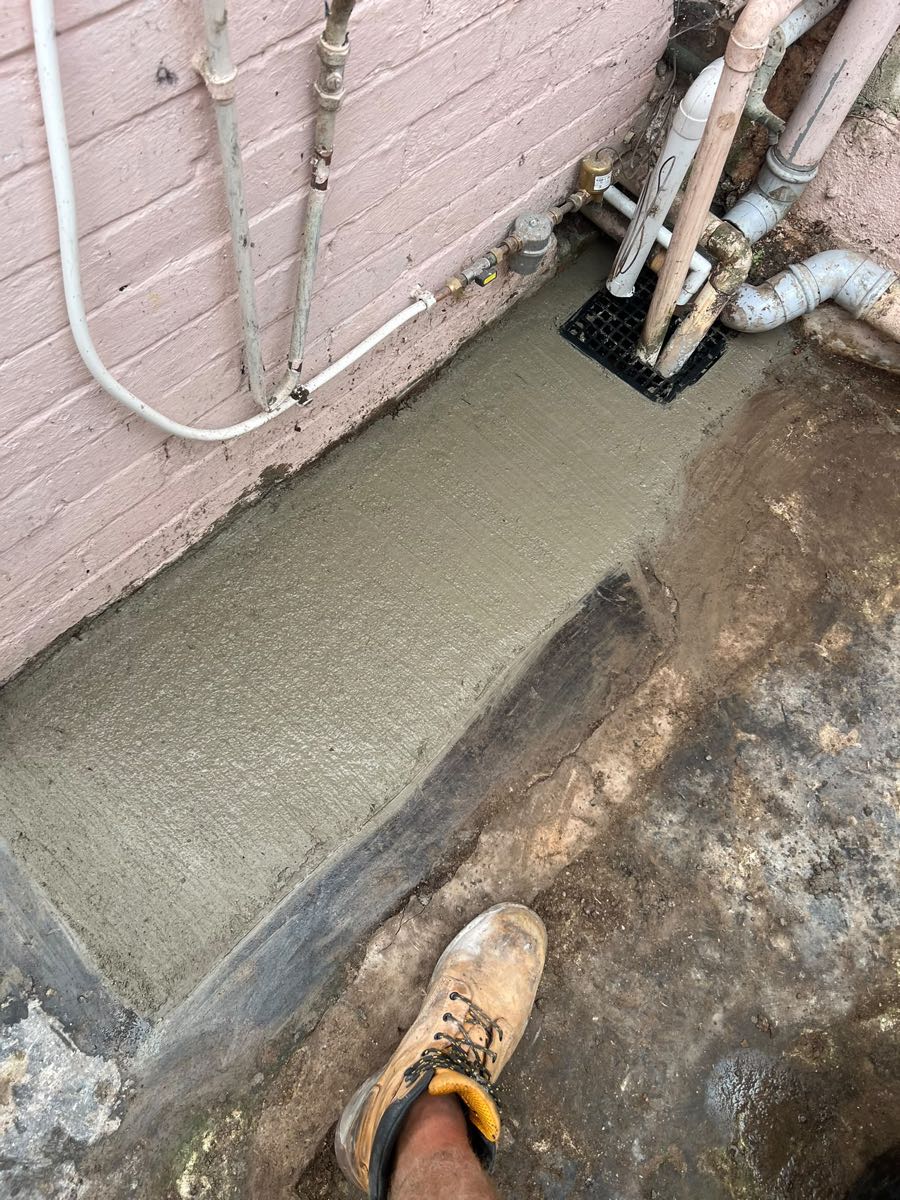 The same passage with the trench filled and fresh concrete laid over it